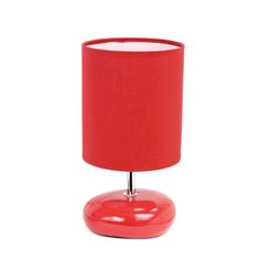 a red table lamp with a white shade on the base and a black light bulb