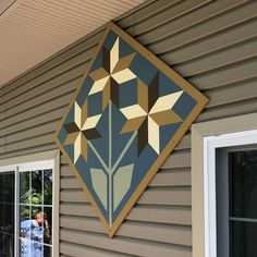 a painting on the side of a house with people standing outside and looking at it