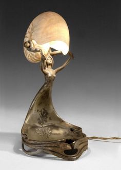 a lamp that is sitting on top of a wooden base with a light bulb in the shape of a woman's head