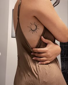 a woman with a sun tattoo on her shoulder