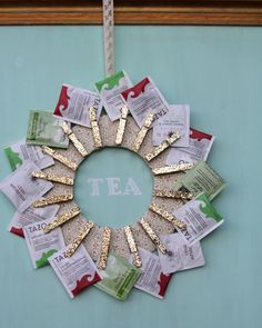 a wreath made out of tea bags and gold foil is hanging on a door with a measuring tape