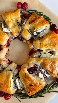 a cranberry and rosemary pastry wreath on top of parchment paper