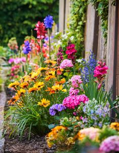 A rustic wooden fence bordered by colorful cottage garden flowers, including red snapdragons, yellow daisies, and purple irises. Wooden Fence, Garden Flowers, Rustic Charm, Fence, Borders