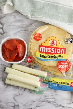 the ingredients to make mission cheese tortillas laid out on a marble counter top