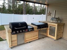 an outdoor kitchen with grill, sink and refrigerator