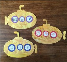 three paper plates with clocks on them sitting on top of a wooden table in the shape of a submarine