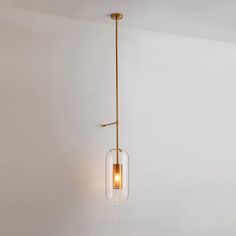 a light fixture hanging from the ceiling in a room with white walls and flooring