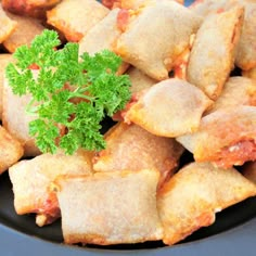 a black plate topped with ravioli and parsley