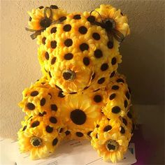 a teddy bear made out of sunflowers sitting on top of a table