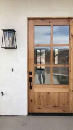 a wooden door with two glass panes and a light on the side of it