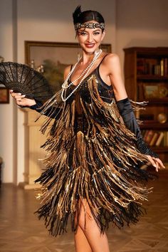 a woman in a black and gold flap dance costume holding an open fan with her right hand