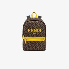 Junior backpack in all-over tobacco-colour FF nylon with yellow Fendi Roma print on the front. Yellow zip pocket on the front and handles in black fabric. Dimensions: Length: 23 cm Height: 33 cm Width: 12 cm Width: 15 cm Made in Italy. One Size Fendi Backpack, Junior Pants, Lycra Leggings, Junior Shirts, Navy Blue Sweatshirt, Fendi Logo, Mid Top Sneakers, Boys Backpacks, Girls Bags