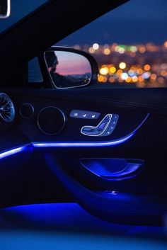 the interior of a car with its lights on and it's dashboard illuminated by blue light