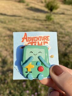 someone is holding up a sticker with an adventure time character on it in their hand