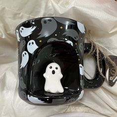 a black and white mug with ghost decorations on it