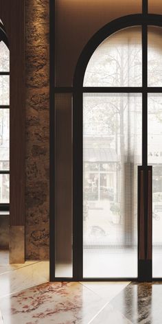 an empty lobby with two large windows and marble flooring in front of the doors