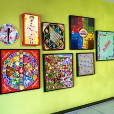 a wall with several different pieces of art on it and a clock mounted to the wall