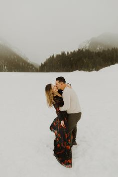 a man and woman kissing in the snow