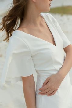 a woman wearing a white dress on the beach