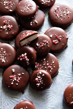 chocolate covered donuts with sprinkles and a bite taken out of one