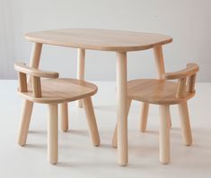 two children's wooden chairs and table on a white surface with one child's chair next to the table