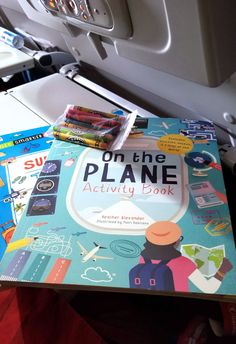 the book on the plane activity book is next to some crayons