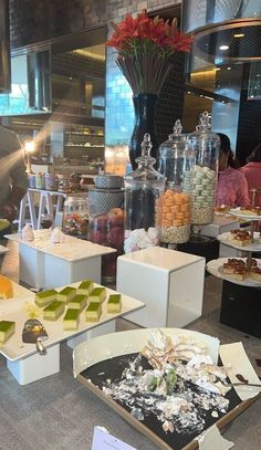 a buffet with many different types of desserts on it's trays and plates