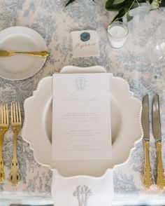 the table is set with silverware and place settings for an elegant wedding reception in blue and white