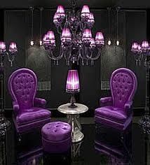 a room with purple furniture and chandelier in the center, all lit up