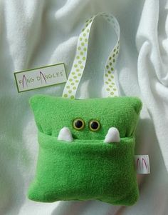 a green stuffed animal with eyes in a pocket