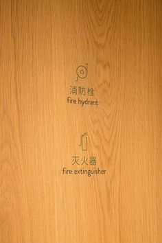 the fire hydrant is written in chinese and english on a wood paneled wall