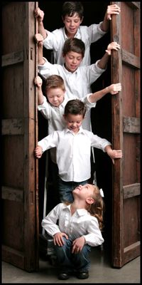 a group of young boys and girls standing in an open doorway