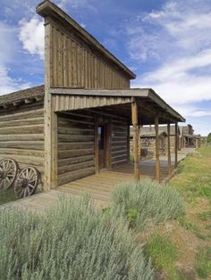 an old wooden building sitting on top of a grass covered field