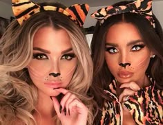 two women in animal costumes posing for a photo on their instagram page, one is wearing a hoodie and the other has her nose painted like a cat