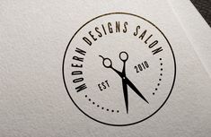 the logo for modern designs salon has scissors in it's center and is black and white