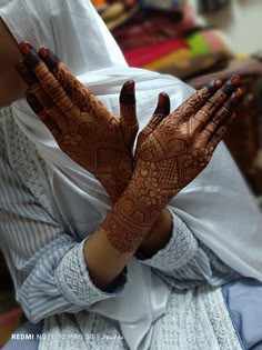 a woman with her hands covered in henna