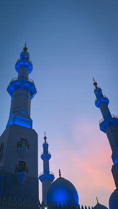 two tall white buildings with blue lights on them