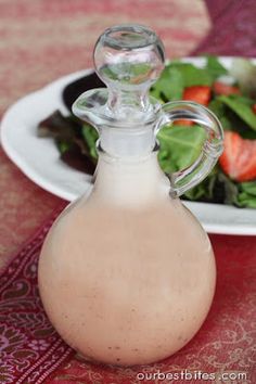 a salad and milk bottle sitting on a table next to a plate with strawberries