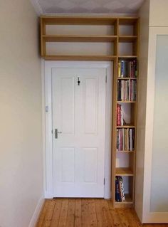 an empty room with bookshelves and a door