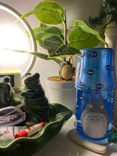 a blue glass vase sitting on top of a table next to a potted plant