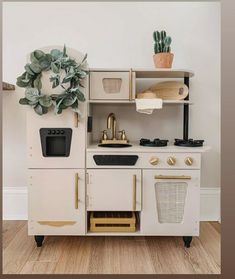 an old fashioned wooden play kitchen with potted plants