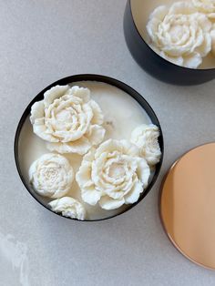 two bowls filled with white flowers on top of a table