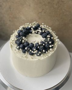 a white cake topped with blueberries and sprinkles on top of a plate