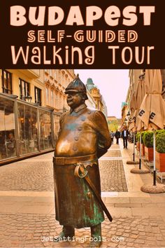 a bronze statue in the middle of a street with text overlay reading budapest self - guided walking tour