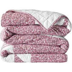 the pink and white floral comforter is folded up on top of each other,