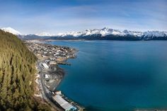 an aerial view of a lake with mountains in the background