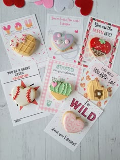 valentine's day cards and magnets are laid out on a white wooden surface