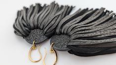 two pairs of black and gold earrings sitting on top of each other