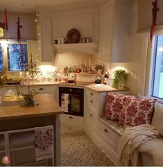 a kitchen filled with lots of counter top space and white cabinets next to a window