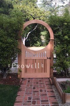 a brick walkway leading to a wooden gate with the word rowetti written on it